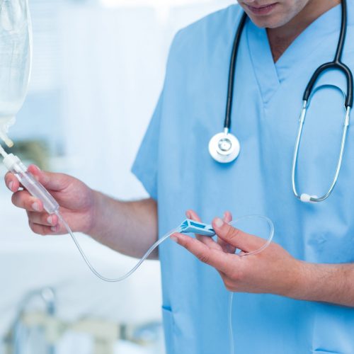 Doctor examining intravenous drip in hospital